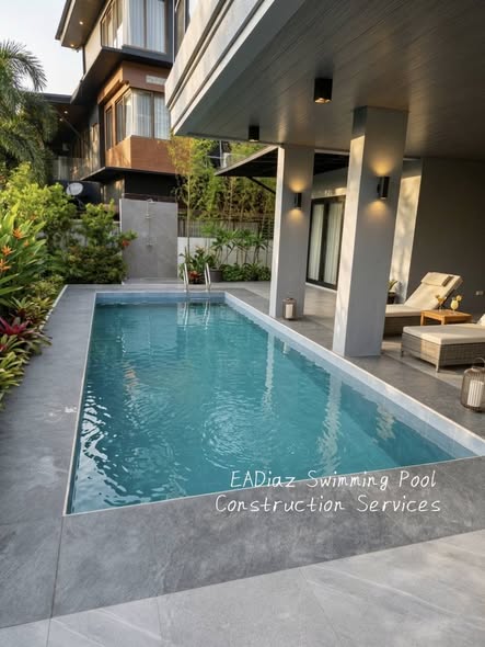 Rectangular pool beside a home and planted garden