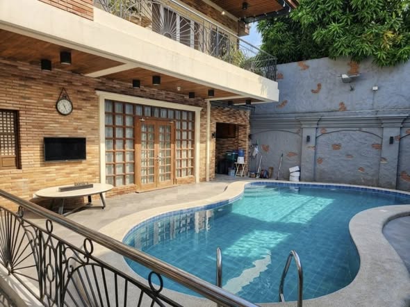 Curved swimming pool beside a home, featured on the EADiaz Facebook page